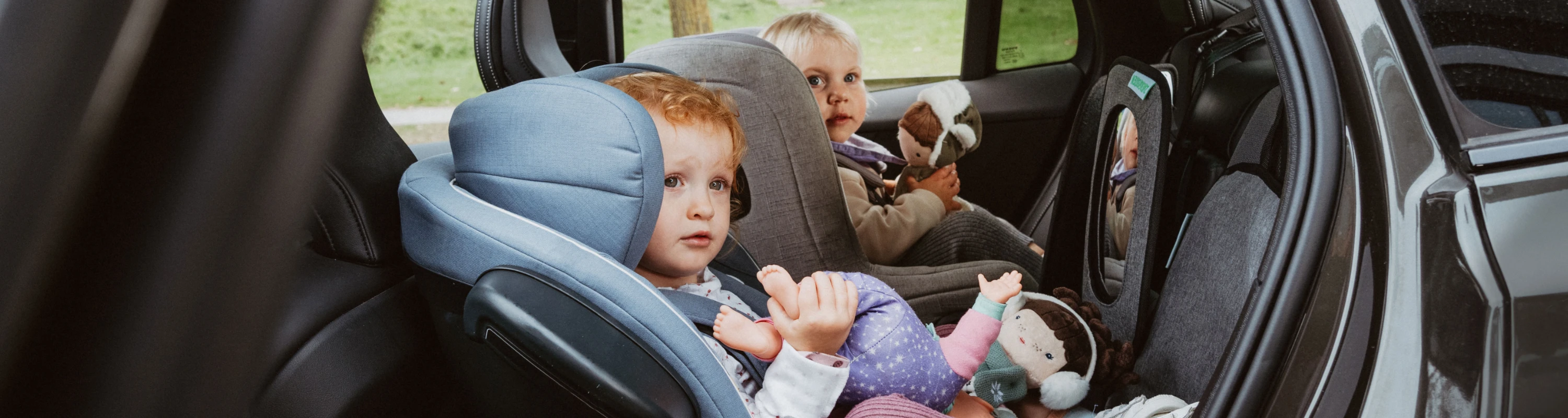 Zwei Mädchen im Reboarder auf der Rückbank im Auto